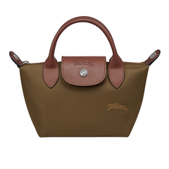 Brown handbag with leather handles and accents on a light gray background Brown handbag with leather handles and accents on a light gray background